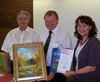 Helmut Wimmer und Ruth Müller überreichen das Bild an LR Eppeneder (Mitte)